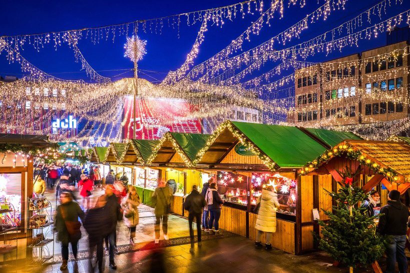 Lichterbögen über den Holzbuden des Internationalen Weihnachtsmarkts in Essen